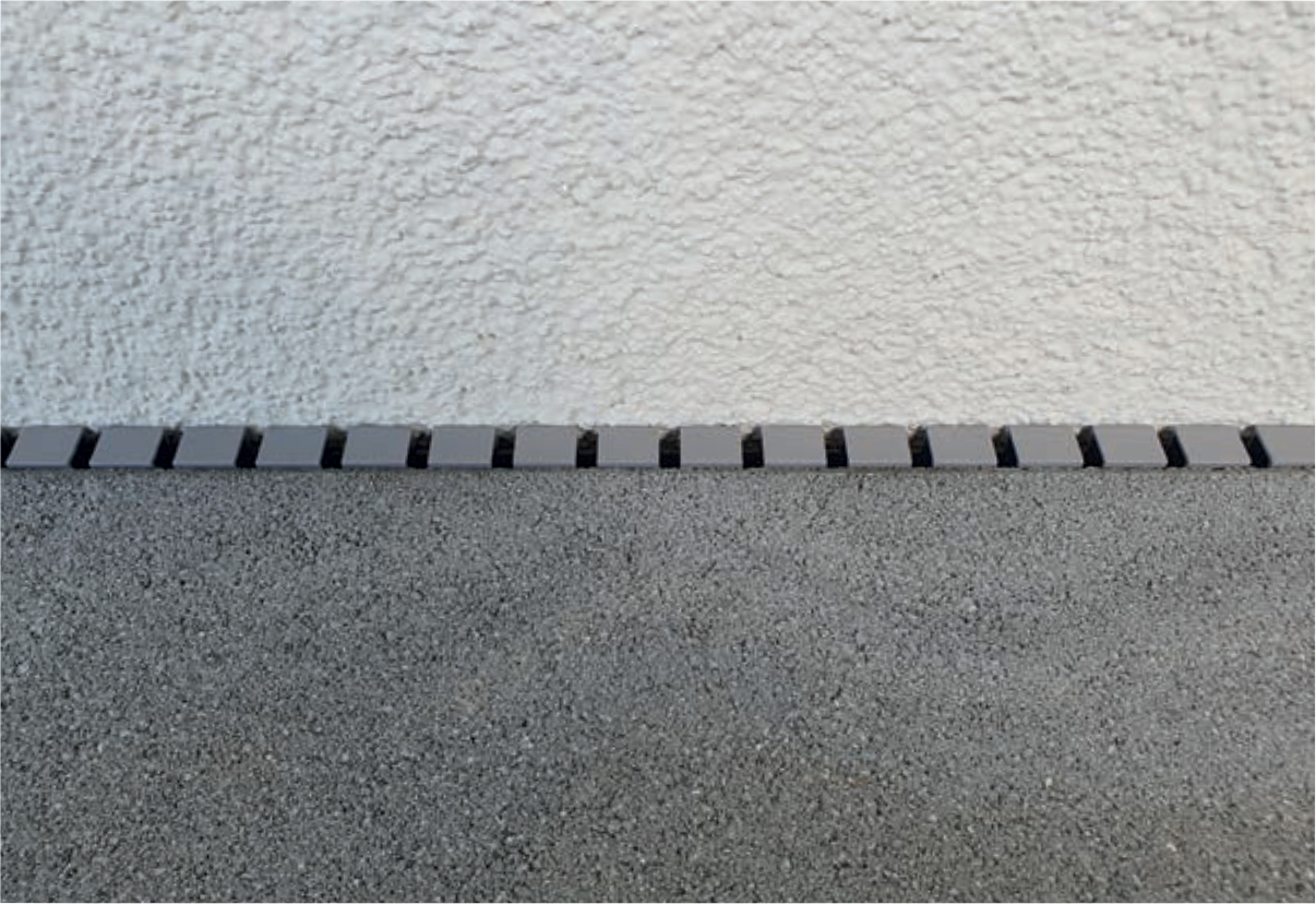Disto® Distanzprofil für Fassadenanschluß, Unauffälliges Profil in steingrau, Lasche verhindert Hochrutschen des Profils.